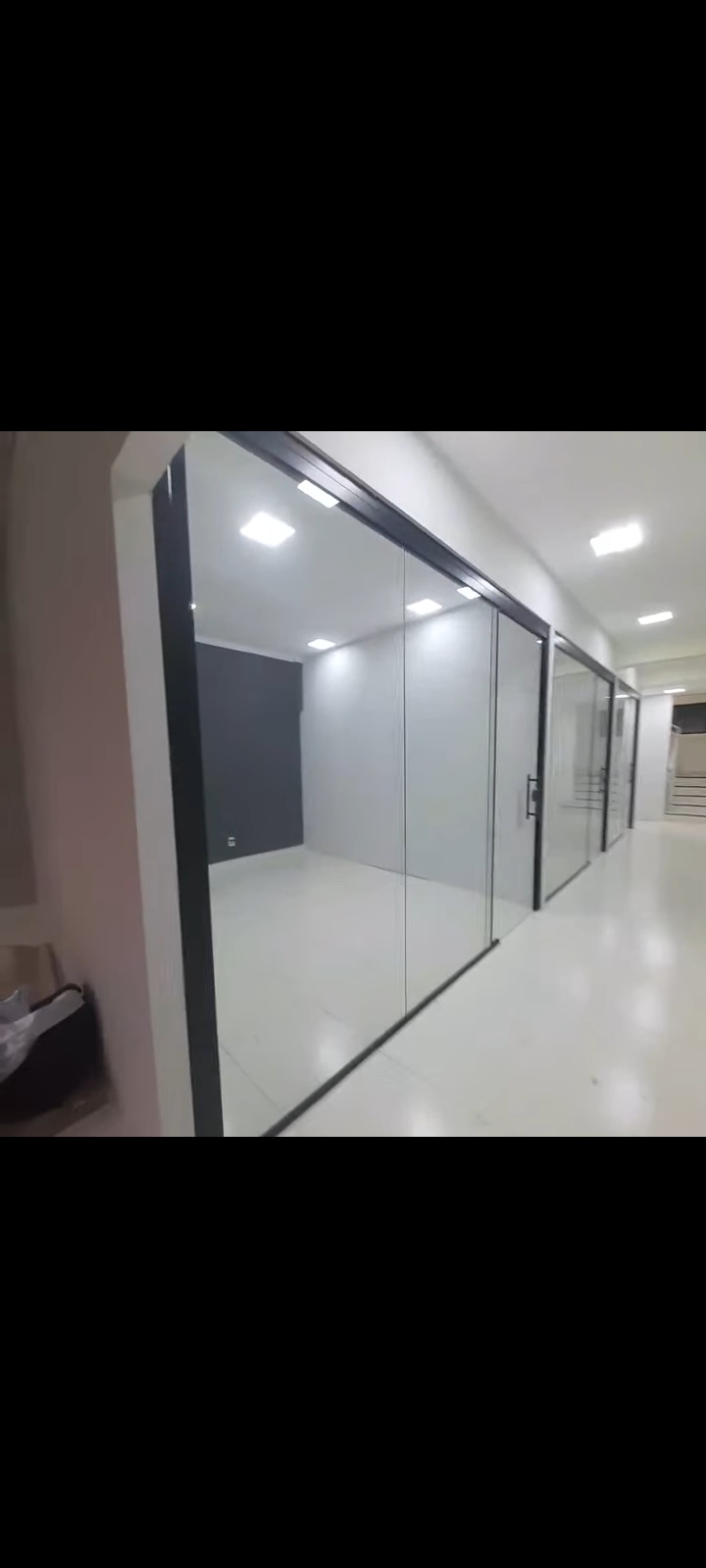 Corredor interno com portas de correr e painéis de vidro